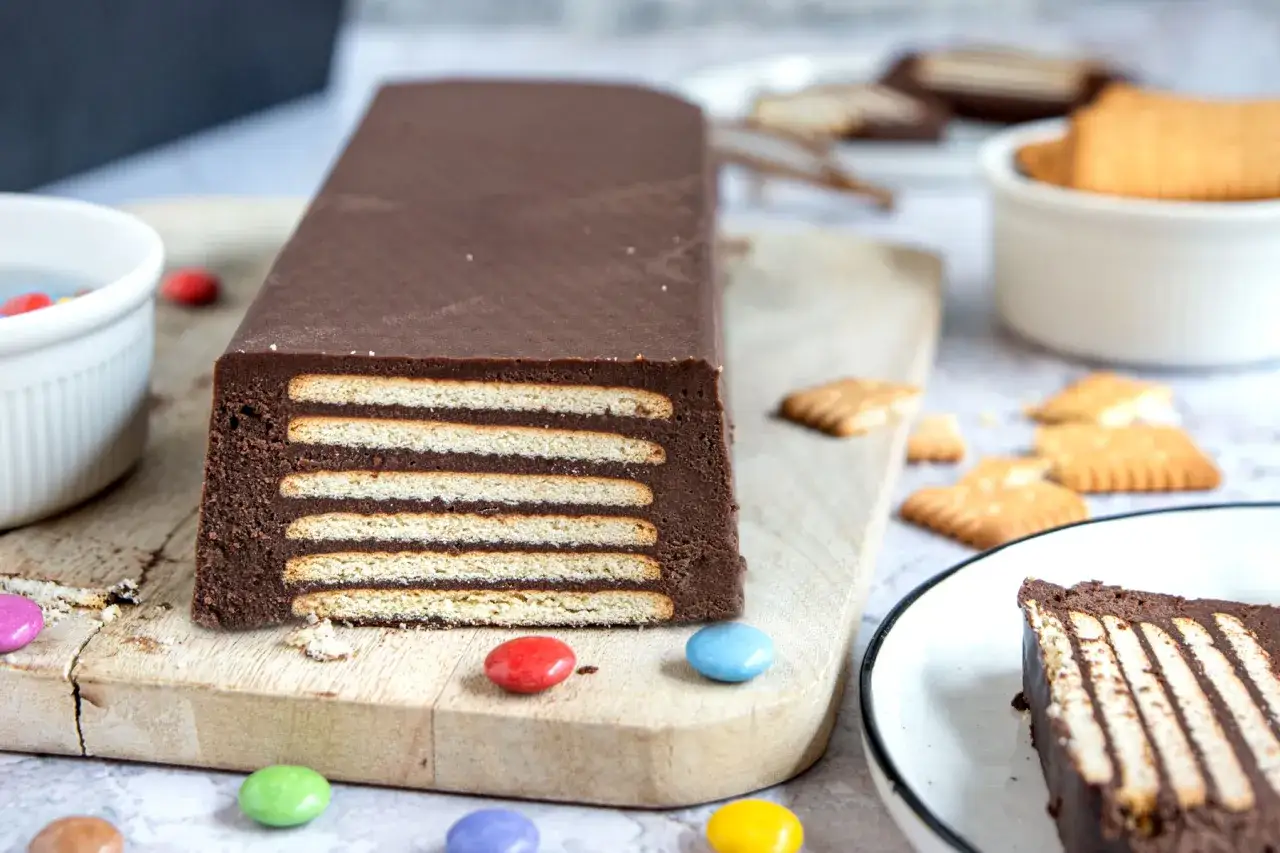 Schokoladige Kekstorte DDR-Art, geschichtet mit Keksen und Schokoladencreme, verziert mit bunten Smarties.