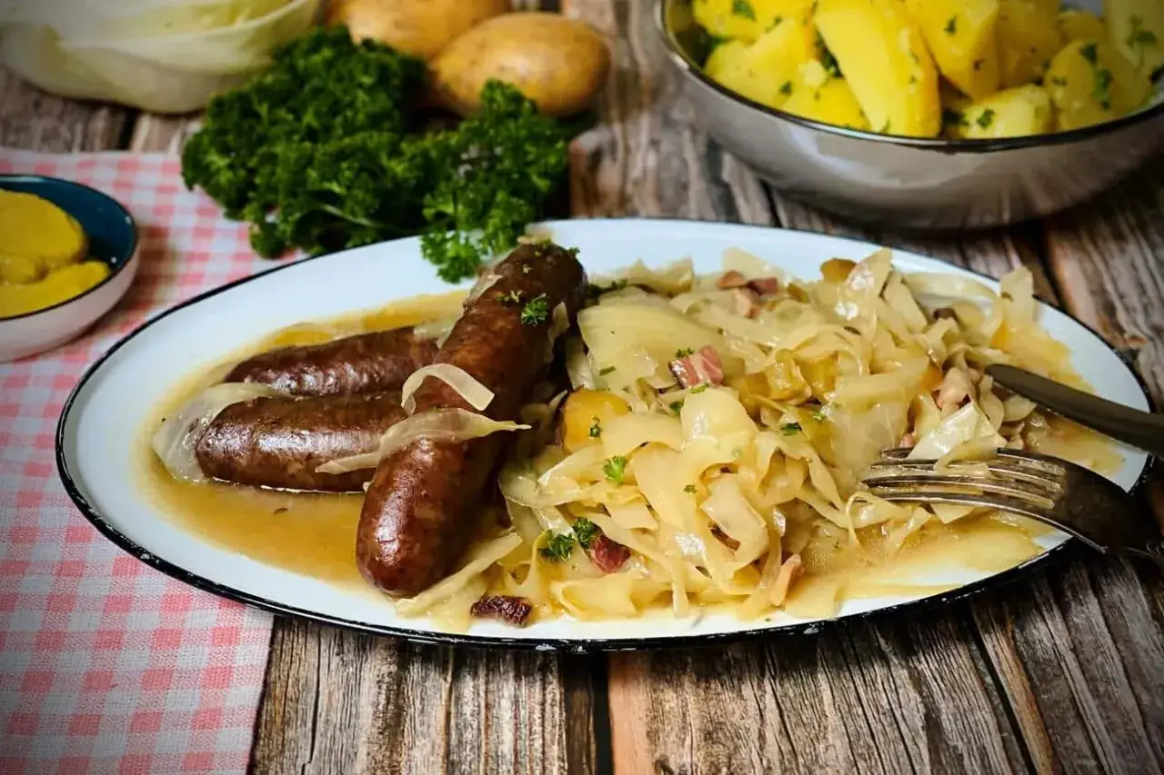 Deftige Bratw&uuml;rste auf omas sauerkraut mit Speck und Zwiebeln, dazu Salzkartoffeln. Ein Klassiker!