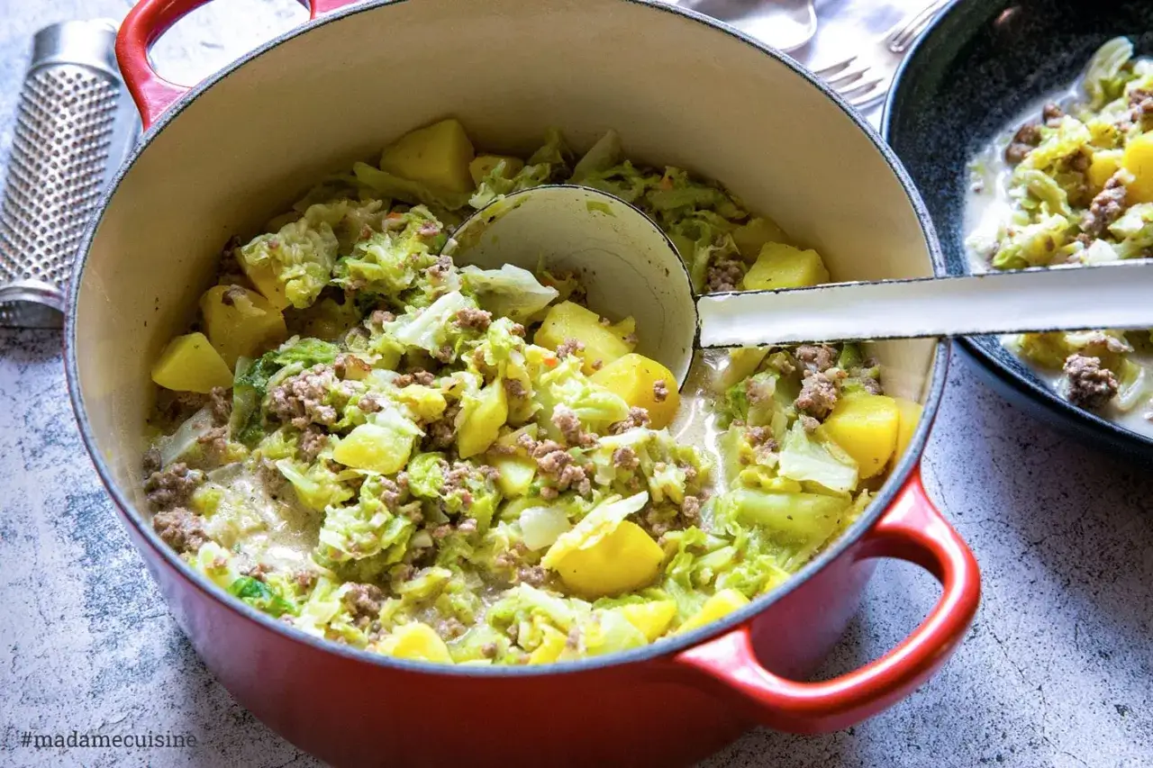 Herzhafte wirsing rezepte einfach: deftiger Eintopf mit Kohl, Kartoffeln und Hackfleisch in einem roten Topf.