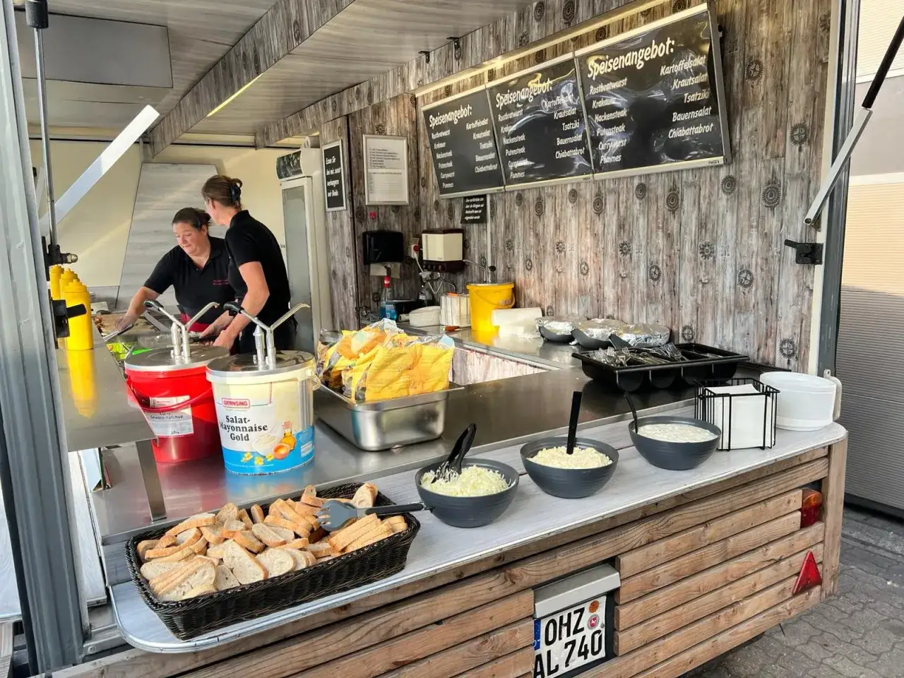 Imbiss-Theke mit Brot, Salaten und gro&szlig;en Beh&auml;ltern f&uuml;r Currywurst-Sauce wie im Imbiss.