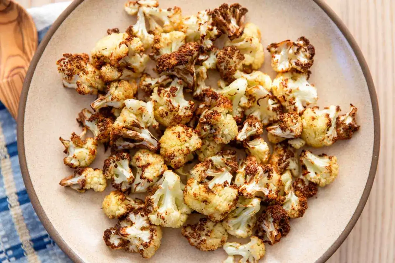 Knuspriger Blumenkohl aus dem Airfryer, goldbraun und perfekt gew&uuml;rzt, liegt auf einem Teller.