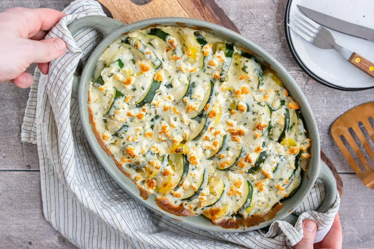 Ein köstlicher Zucchini Kartoffel Feta Auflauf, goldbraun gebacken und mit Kräutern bestreut. Perfekt für ein leichtes Abendessen.