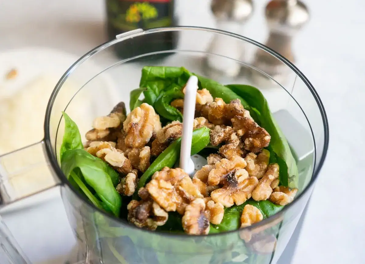 Gr&uuml;ne Bl&auml;tter und Waln&uuml;sse im Mixer f&uuml;r verschiedene Pesto-Arten.
