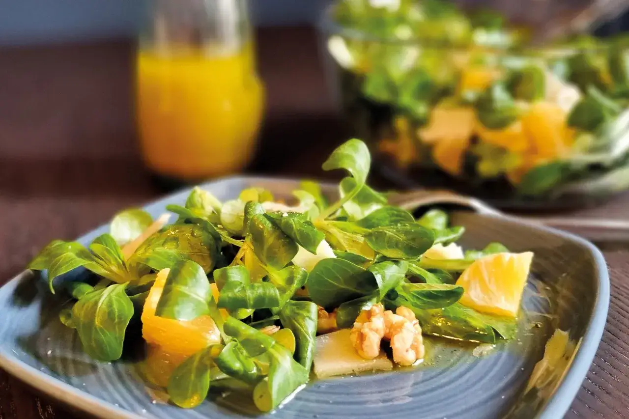 Ein frischer Feldsalat mit Orangenstücken und Walnüssen, verfeinert mit einem leckeren honig senf dressing.