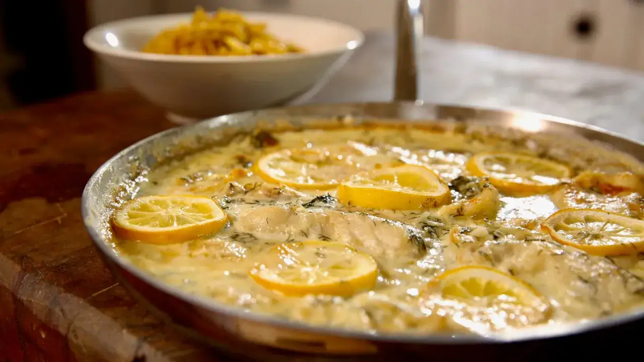 Fisch in cremiger Zitronen-Dill-Sauce, perfekt als schnelle Sauce zu Fisch und Reis. Daneben eine Sch&uuml;ssel mit gelbem Reis.