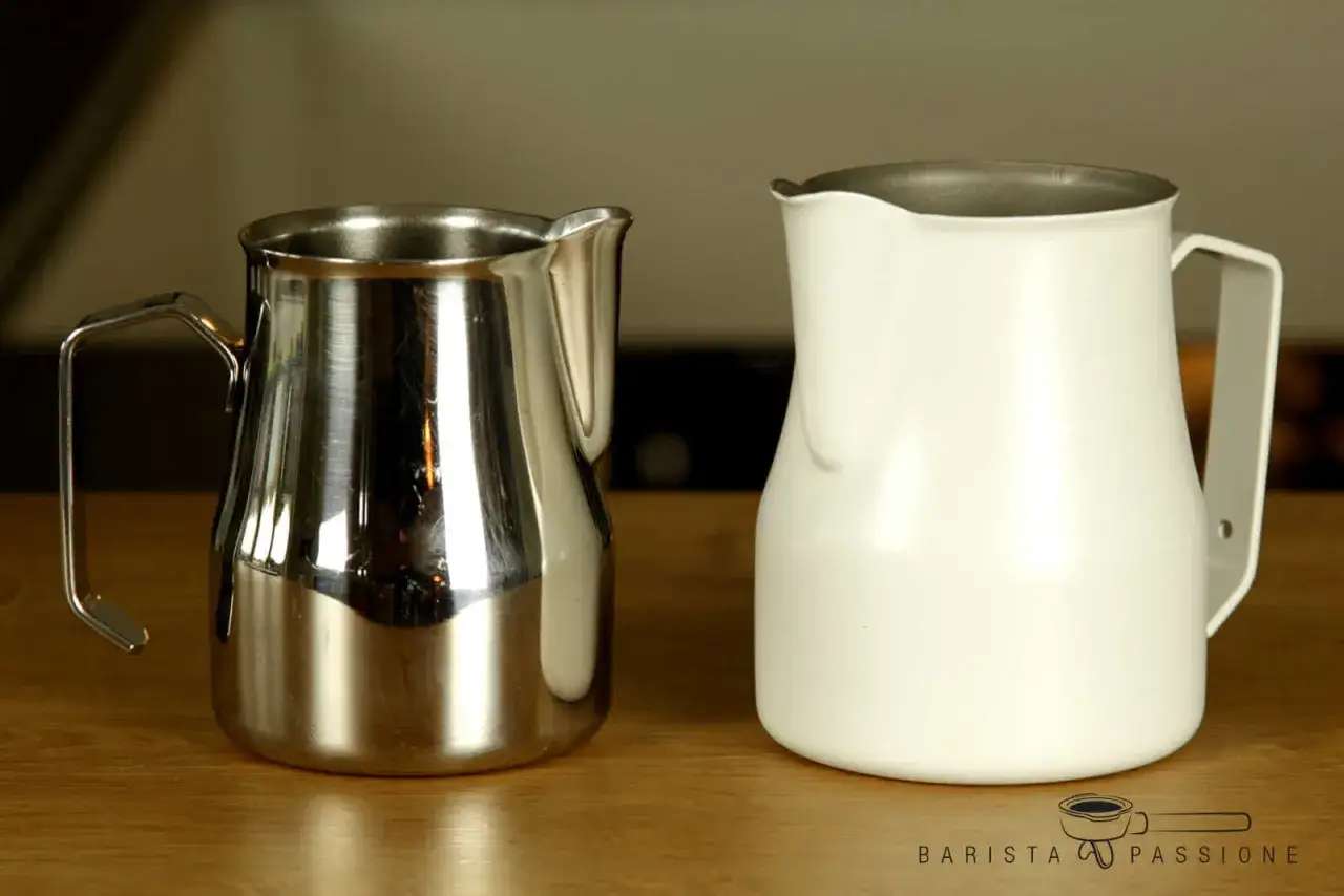 Zwei Milchk&auml;nnchen, eines aus gl&auml;nzendem Edelstahl, das andere wei&szlig;, bereit f&uuml;r perfekten Kaffee-Schaum.