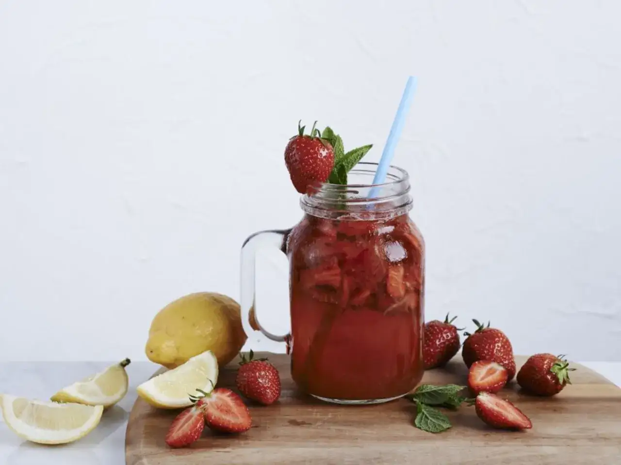 Erfrischende alkoholfreie Erdbeerbowle im Glas mit frischen Erdbeeren, Zitronenscheiben und Minze.