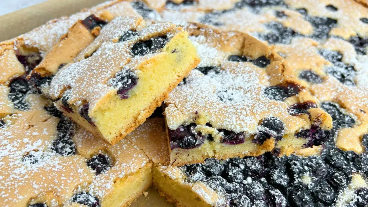 Saftiger Blaubeerkuchen, perfekt zum Kuchen backen mit Tassenangabe. Mit Puderzucker bestäubt und voller Blaubeeren.