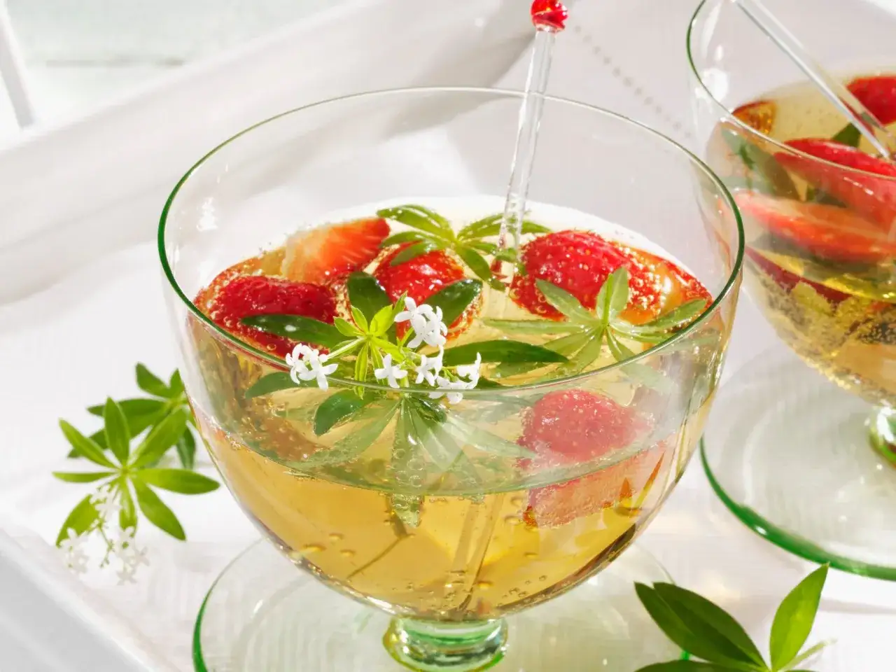 Erfrischende Mai-Bowle mit Erdbeeren und Waldmeister in einem Glas.