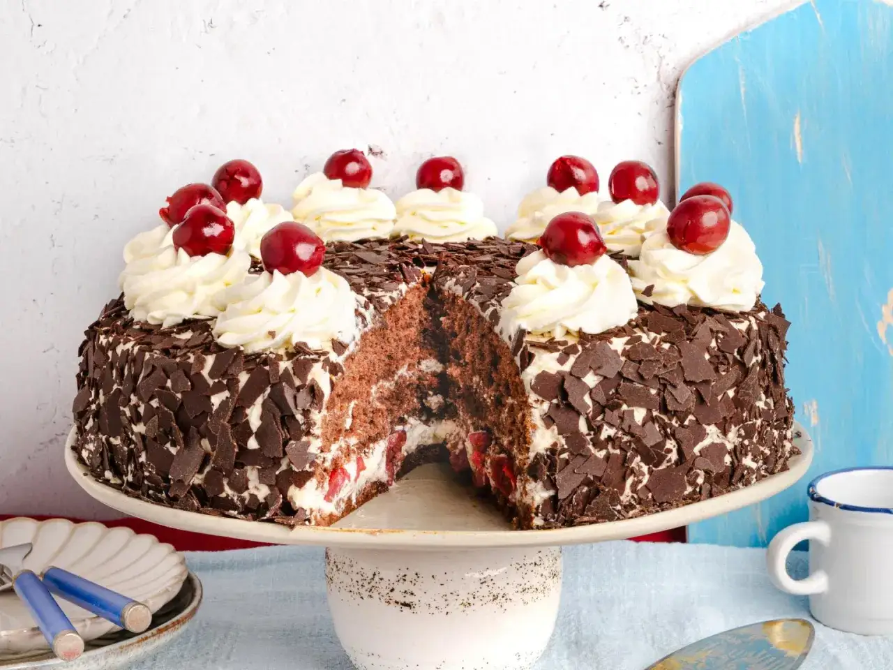 Schwarzw&auml;lder Kirschtorte, ein Klassiker aus Omas besten Kuchen Rezepten, mit Sahnetupfern und Kirschen verziert.