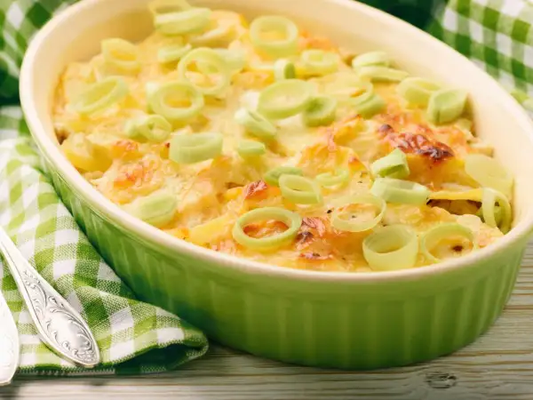 Ein köstlicher, schneller Auflauf mit Lachs und Kartoffeln, überbacken mit Käse und garniert mit Lauchringen.