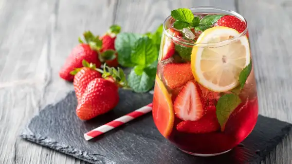Erfrischende alkoholfreie Erdbeerbowle mit frischen Erdbeeren, Zitrone und Minze in einem Glas.