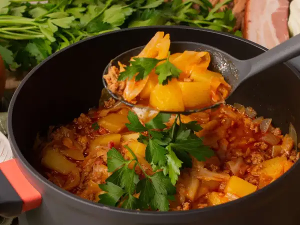 Schichtkohl nach Omas Rezept: herzhaftes Gericht mit Kohl, Hackfleisch und Kartoffeln, garniert mit Petersilie.