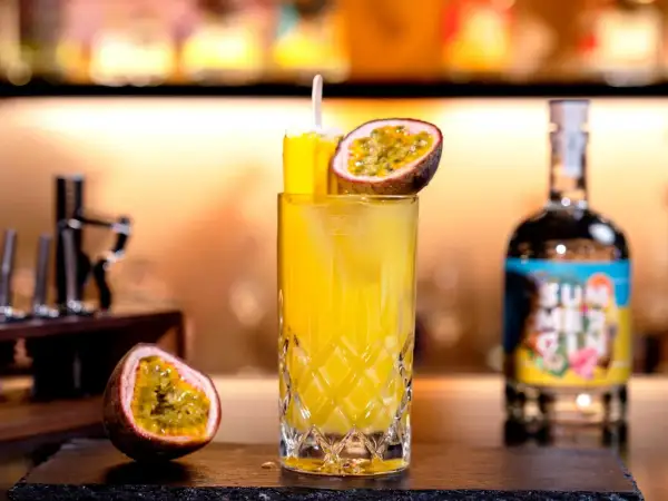 Erfrischender Solero Cocktail mit Passionsfrucht und Eis, garniert mit einem Eisstiel.