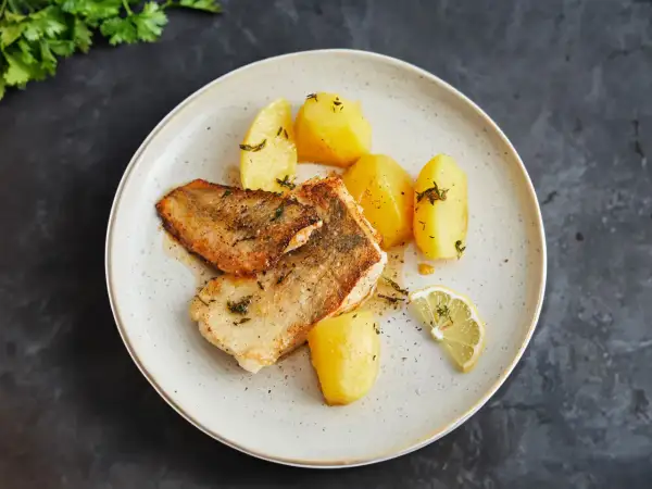 Gebratene Fischfilets mit Salzkartoffeln und Zitrone – so einfach lässt sich eine köstliche Fischplatte selber machen.