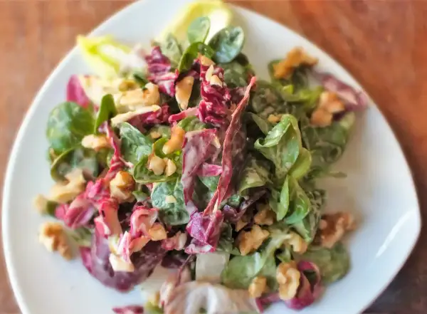 Frischer Feldsalat mit Radicchio und Walnüssen, verfeinert mit einem cremigen Kartoffeldressing.