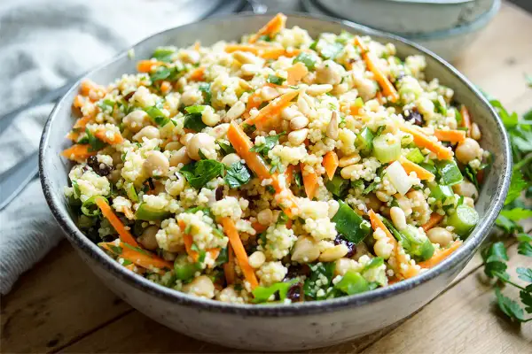 Bunter Hirse Salat mit Kichererbsen, Karottenstreifen und Pinienkernen. Ein leichter und gesunder Genuss.